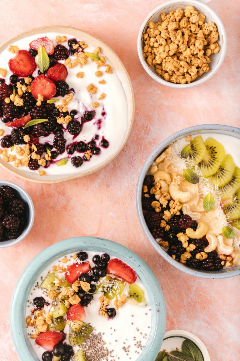 Variety of yogurt bowls with fresh fruit, nuts, and granola. Perfect for a healthy breakfast or lunch.